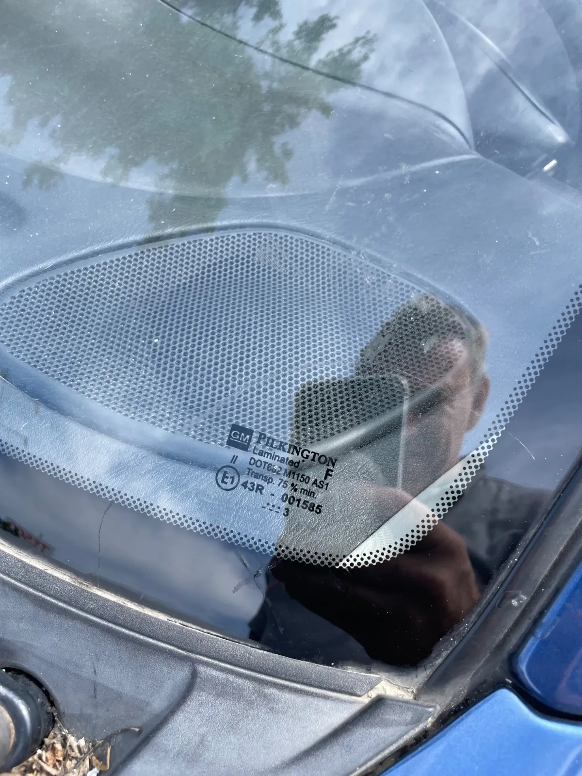 Hosszú repedés egy kék autó szélvédőjén