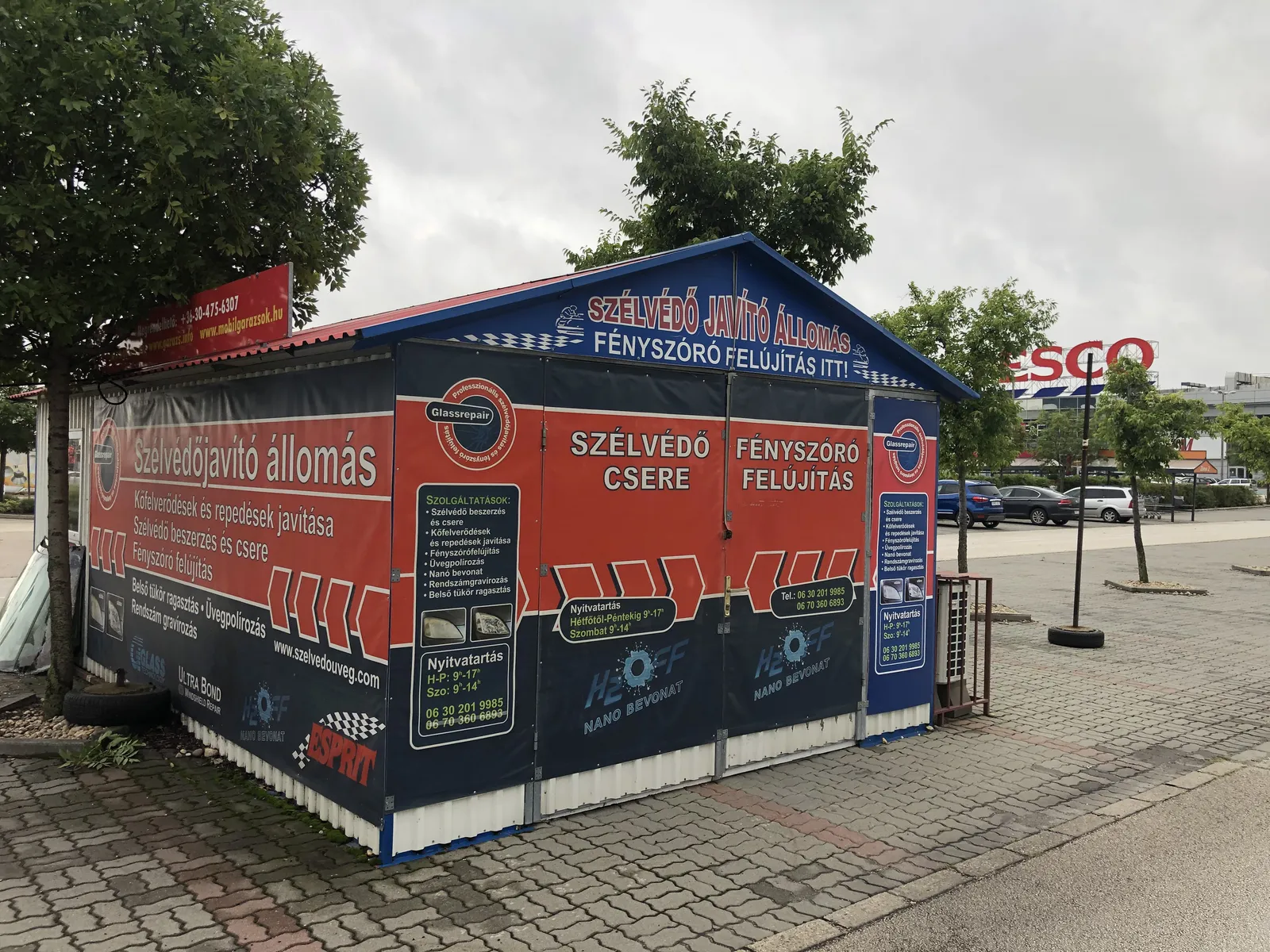 A Szélvédő Javító Állomás pavilonja egy Tesco parkolójában